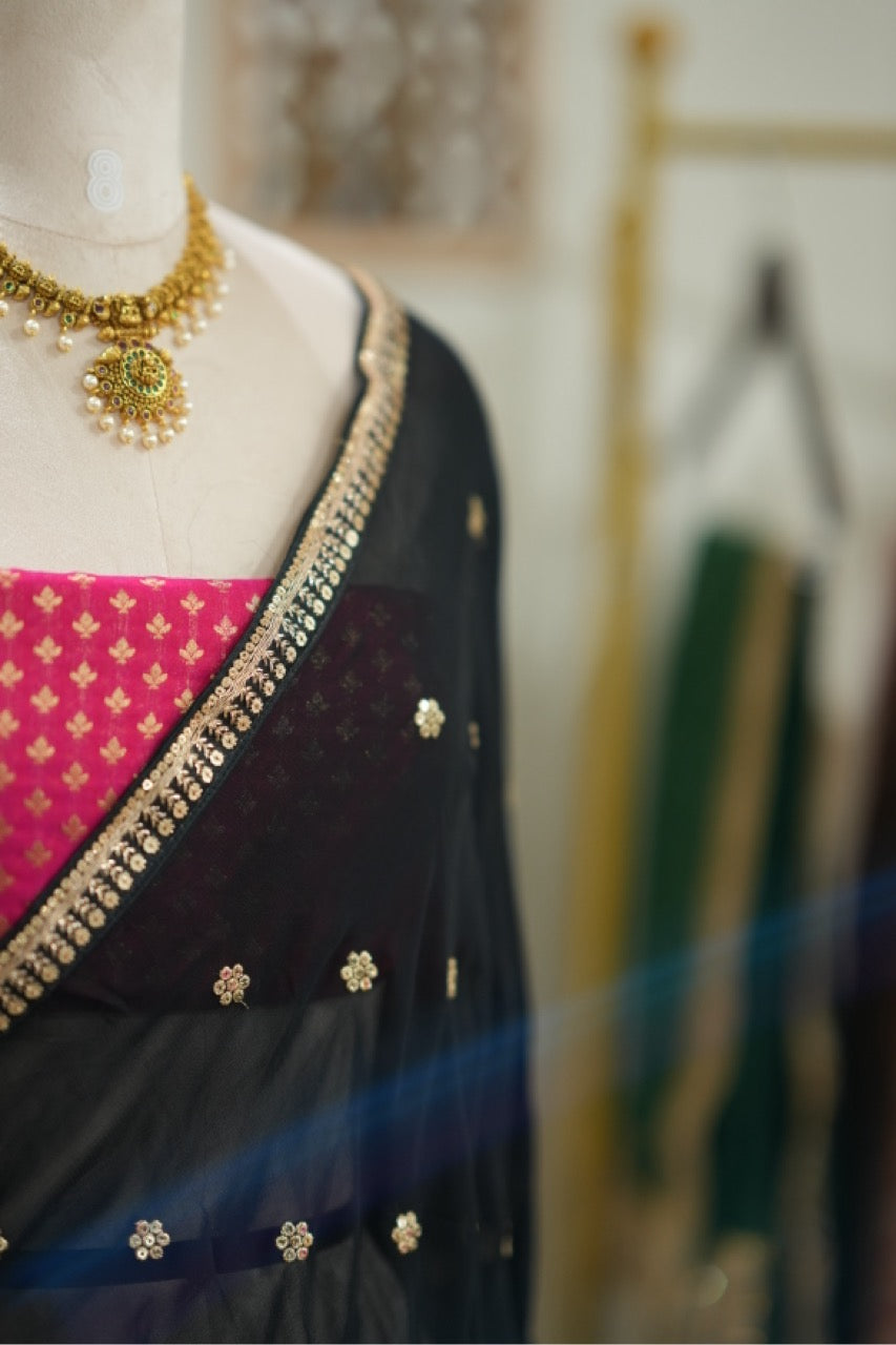 Smokey eyes: Black georgette saree with pink brocade blouse