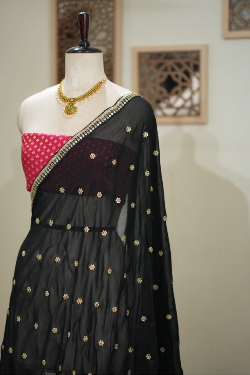 Smokey eyes: Black georgette saree with pink brocade blouse
