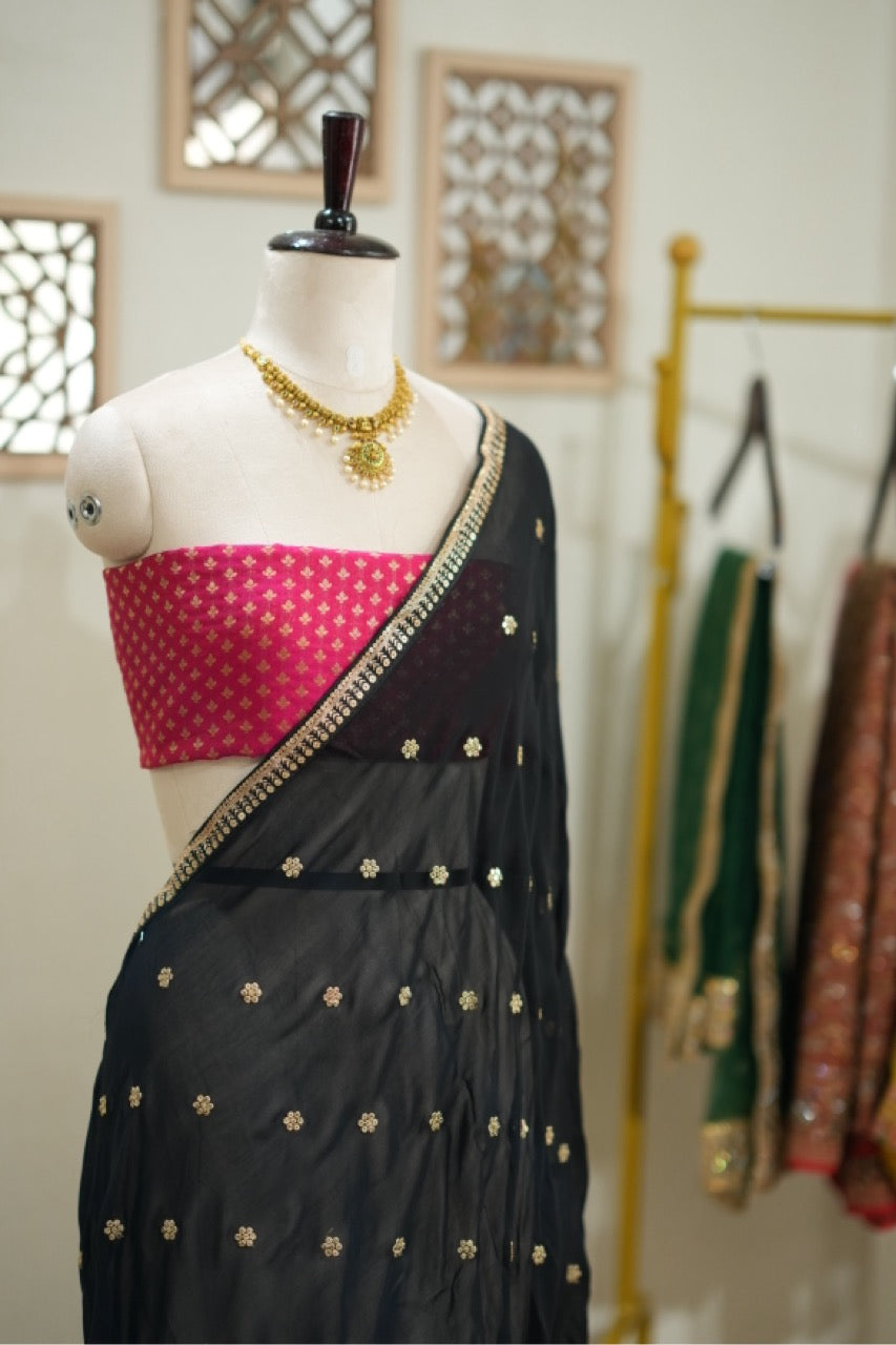 Smokey eyes: Black georgette saree with pink brocade blouse