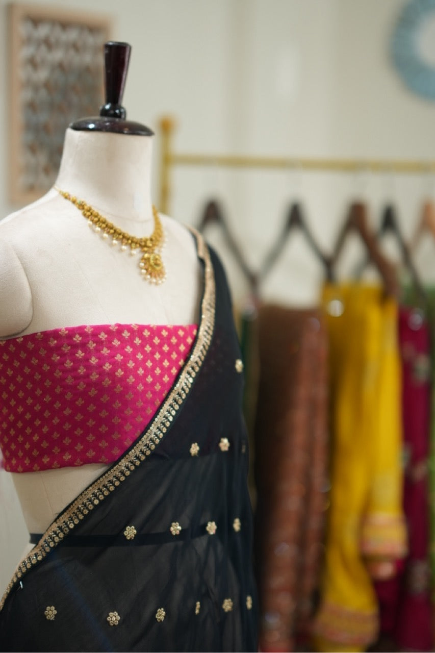 Smokey eyes: Black georgette saree with pink brocade blouse