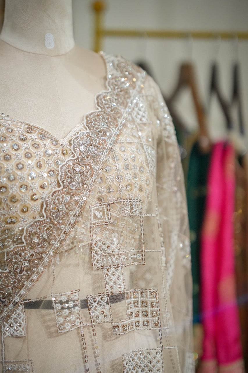 Tusker: Ivory Softnet Saree with Handwork paired with self handwork blouse.